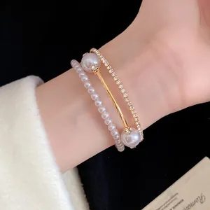 Close-up of elegant three-layered gold bracelet with pearls and shimmering crystals.