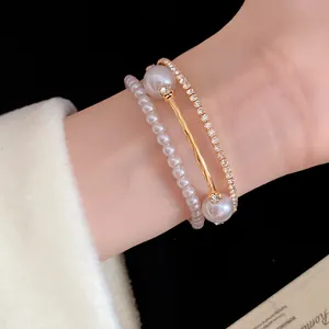 Close-up of an elegant three-layer bracelet set featuring pearls and rhinestones on a wrist