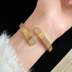 Close-up of a luxury 18k gold plated geometric cuff bracelet with sparkling zircons.