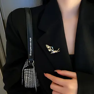 Detailed view of elegant gold floral brooch with sparkling rhinestones on a black blazer lapel