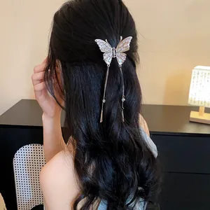 Eleganter Schmetterlings-Haarclip mit Strass und langen Quasten auf dunklem Haar.