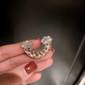 Detailed view of a crescent moon brooch with glittering rhinestones and gold finish