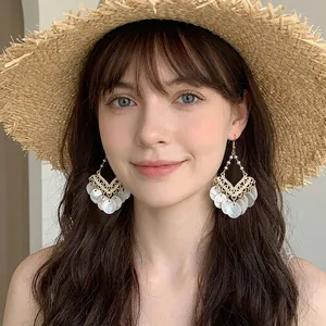 Exaggerated vintage style drop earrings with white shell pendants and gold frame