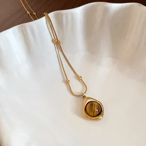 Detalle del collar vintage con colgante en forma de lágrima y piedra ojo de tigre