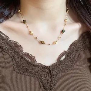 Primer plano detallado de un collar retro de ojo de tigre sobre un top de encaje