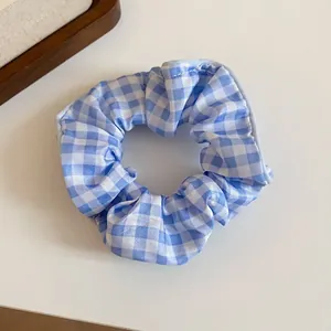Detailed view of the blue and white checkered fabric hair scrunchie texture