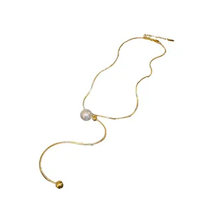 Elegant adjustable gold snake chain necklace with pearl and metal bead tassel.