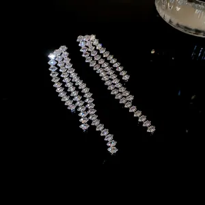 Nahaufnahme von funkelnden Voll-Diamant-Quastenohrringen auf schwarzem Grund