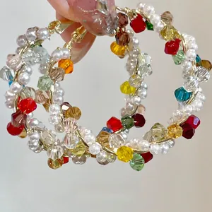 Colorful handmade crystal and faux pearl hoop earrings with elegant gold wire wrap detail.