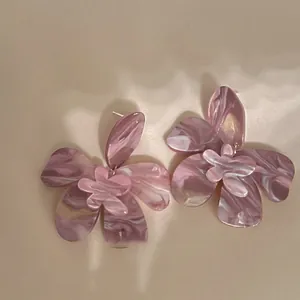 Macro detail of mauve marble resin flower earrings with artistic swirl pattern and layered petals.