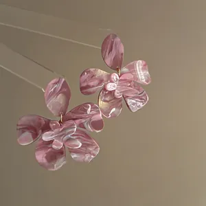 Detailed view of pink marbled resin flower earrings featuring elegant layered petal design.