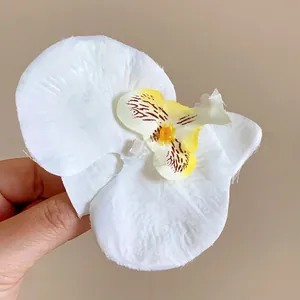 Gros plan d'une pince à cheveux orchidée blanche en tissu avec texture réaliste.