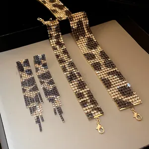 Close-up detail of luxury leopard print rhinestone necklace set and matching tassel earrings