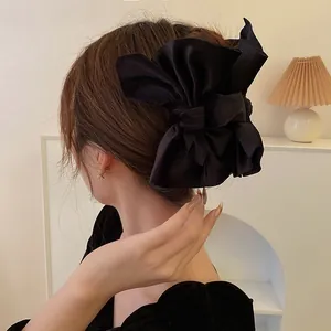 Eleganter großer schwarzer Haarkrebs mit Stoffschleife, am Modell für einen edlen Alltagslook