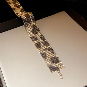 Detailed macro shot of sparkling rhinestone leopard print pattern on a wide choker