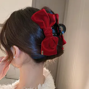 Detail einer eleganten großen Haarklammer mit roter Samtschleife für einen Haardutt.