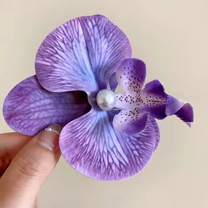 Gros plan détaillé d'une pince à cheveux orchidée violette avec perle centrale