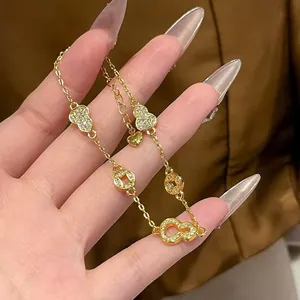Macro view of 24K gold plated charm bracelet featuring zircon gourds and coins