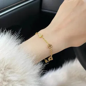 Close-up of 24K gold plated zircon bracelet with gourd and coin charms on wrist