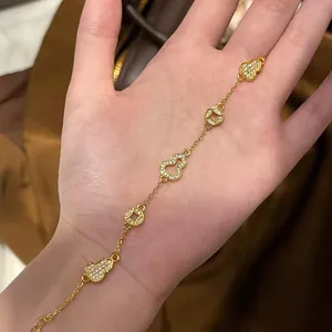 Detail view of a luxury 24K gold plated gourd and coin bracelet with sparkling zircons.