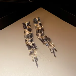 Detail view of leopard print rhinestone tassel earrings with a vintage golden finish