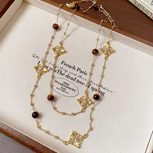 Vintage gold-toned long sweater necklace with crystal cross motifs and tiger eye beads