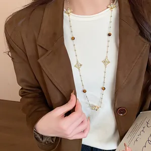 Detailed view of a vintage long sweater chain with sparkling cross pendants and beads