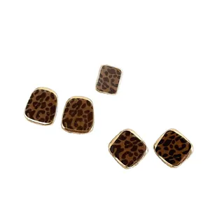 Elegant gold-framed flocked leopard print stud earrings set on a clean white background