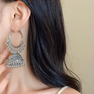 Macro view showing detailed texture of ethnic silver Jhumka earrings with bead tassels.
