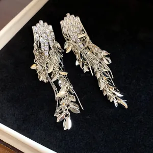 Detailed view of silver zircon tassel earrings featuring wheat ear leaf design on dark velvet