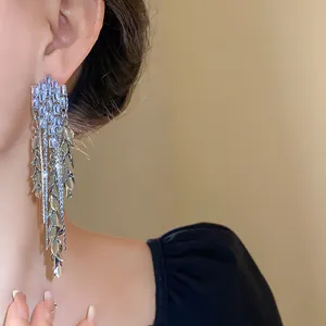 Detailed close-up of sparkling zircon wheat-ear leaf tassel earrings worn on model ear