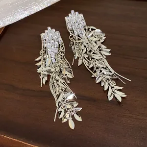 Detail view of silver-toned wheat leaf tassel earrings with sparkling zircon stones