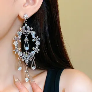 Statement rhinestone hollow teardrop tassel earrings with silver needle on model