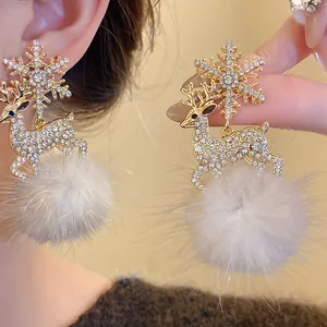 Close-up of rhinestone elk earrings with snowflake and grey pom-pom details