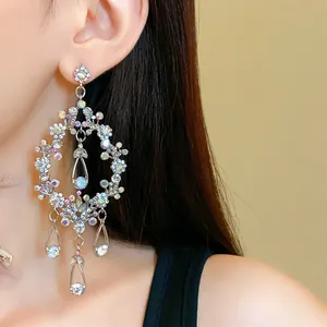 Intricate silver-tone waterdrop tassel earrings with shimmering rhinestones on model