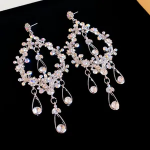 Detailed view of silver needle teardrop fringe earrings with sparkling rhinestones