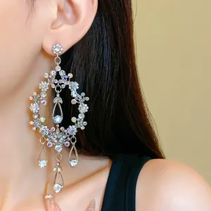 Close-up of silver-tone chandelier earrings with sparkling rhinestones and tassels