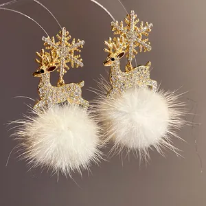 Close-up of reindeer and snowflake earrings with sparkly stones and soft fur ball