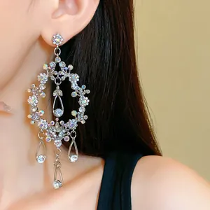 Close-up of elegant hollowed-out teardrop earrings with sparkling rhinestones and tassels