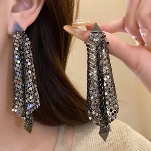 Close-up view of shimmering gunmetal sequin tassel earrings featuring triangular studs