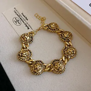 Primo piano di un bracciale vintage color oro con teste di leone e design intricato
