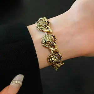 Primo piano dei dettagli degli intricati ciondoli a testa di leone in oro su bracciale.