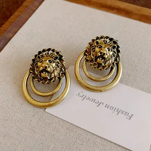 Macro di orecchini vintage a testa di leone in oro antico con design a doppio cerchio