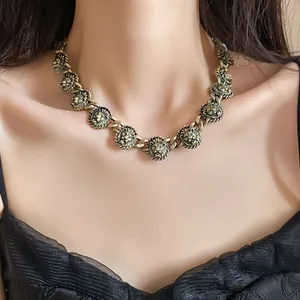 Dettaglio di una collana a maglie con testa di leone in finitura bronzo vintage da donna