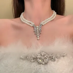 Exquisite close-up of a double-layer pearl necklace featuring a diamond tassel pendant