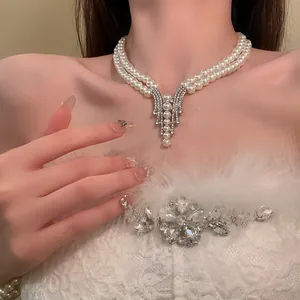 Close-up of elegant double-layer pearl necklace with rhinestone pendant on a model