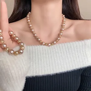 Élégant collier vintage français avec perles champagne et perles géométriques dorées.