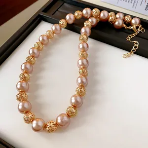Gros plan d'un collier rétro français avec perles roses et perles dorées texturées