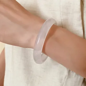 Close-up shot of a minimalist translucent white resin bangle worn on a female wrist