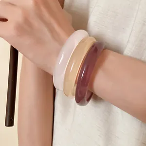 Detail view of stacked colorful resin bangles in New Chinese style on wrist